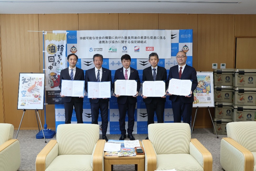 At the signing ceremony (From left: Yuki Nishimura, Chief Operating Officer (COO) of SAFFAIRE SKY ENERGY; Tetsuya Koshikawa, Representative Director and CEO of REVO International; Tetsuji Arifuku, Mayor of Sakaide City; Masahiro Horiguchi, General Manager of Cosmo Oil's Sakaide Distribution Terminal; and Masahiro Aika, Executive Vice President of JGC HD)